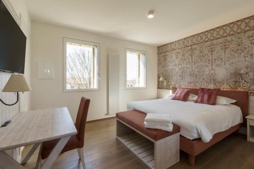a bedroom with a bed and a table and a desk at Ca' Barbieri San Donà in San Donà di Piave