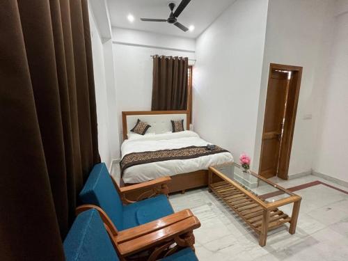 1 dormitorio con 1 cama y 1 silla azul en SRH HOTEL, en Greater Noida