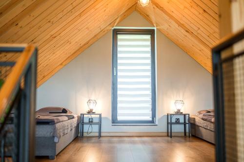 a attic room with two beds and a window at Bieszczadzka Pauza in Polańczyk