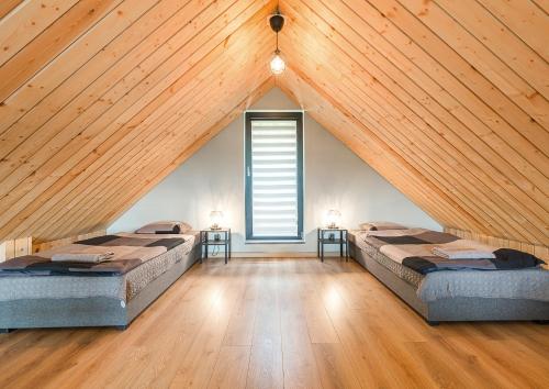 a attic room with two beds and a window at Bieszczadzka Pauza in Polańczyk
