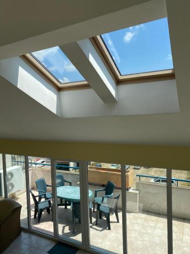 a skylight in a living room with a table and chairs at Prostor Apartments in Obzor