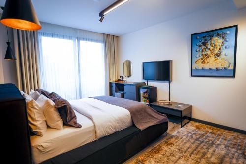 a bedroom with a large bed and a television at Çathan Art Hotel in Ayder Yaylasi