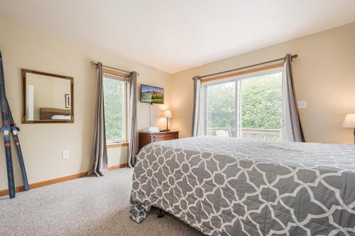 a bedroom with a bed and a large window at Duck Cove at Wisp in McHenry