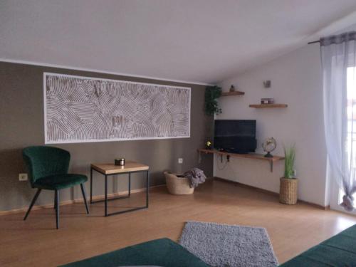a living room with a green chair and a television at Apartments Anita Frane in Vodice