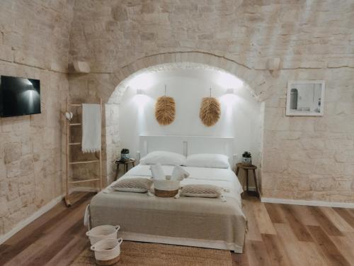 ein Schlafzimmer mit einem großen Bett in einer Steinmauer in der Unterkunft Casa De Amicis in Sammichele di Bari