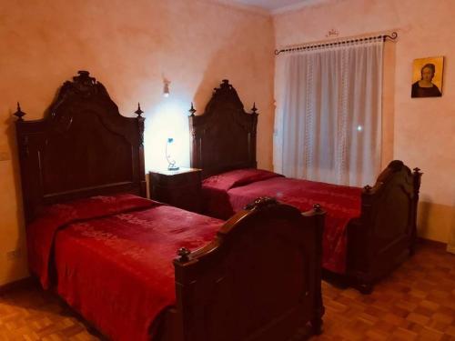 a bedroom with two beds with red sheets at Corte dei Molini in Faedis