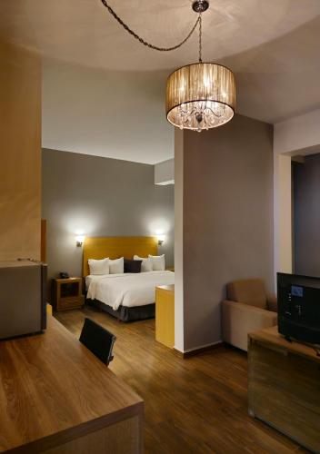 a hotel room with a bed and a television at Bluu Hotel Aeropuerto Monclova-Frontera in Monclova