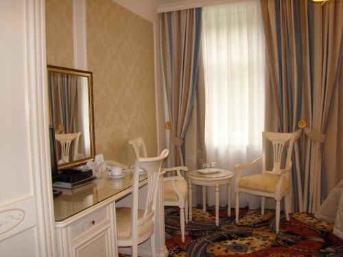 a room with a desk and chairs and a mirror at Hotel Saint Petersburg in Karlovy Vary
