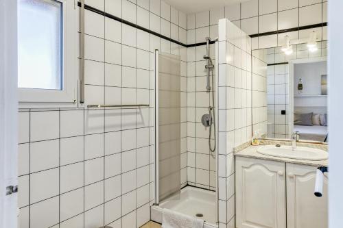a white tiled bathroom with a shower and a sink at Art- Apartamentos Revilla Tacke D in Empuriabrava