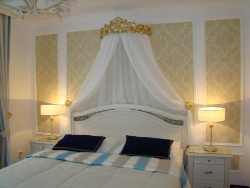 a bedroom with a white bed with a crown above it at Hotel Saint Petersburg in Karlovy Vary