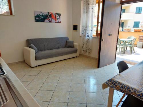 uma sala de estar com um sofá e uma mesa em casa delle margherite Ladispoli em Ladispoli