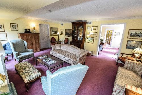 a living room with a couch and two chairs at Blairpen House Country Inn in Niagara on the Lake