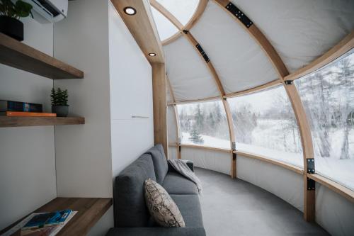 a living room with a couch and a large window at Station Boréale in Val-dʼOr