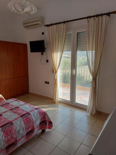 a bedroom with a bed and a sliding glass door at Seaview Saravari Studios in Áyios Aléxandros