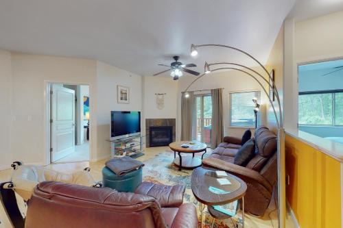 a living room with leather furniture and a flat screen tv at Creekside Retreat C203 in Girdwood