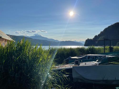 a couple of boats in the grass next to a lake at Landhaus Schönblick in Radenthein