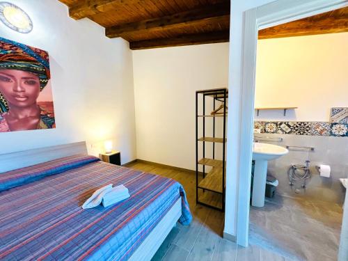 1 dormitorio en una villa con cama y lavamanos en Amuri en Cinisi