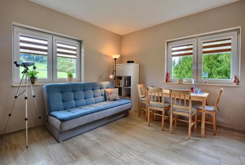 uma sala de estar com um sofá azul e uma mesa em Domek Limba em Ustrzyki Dolne