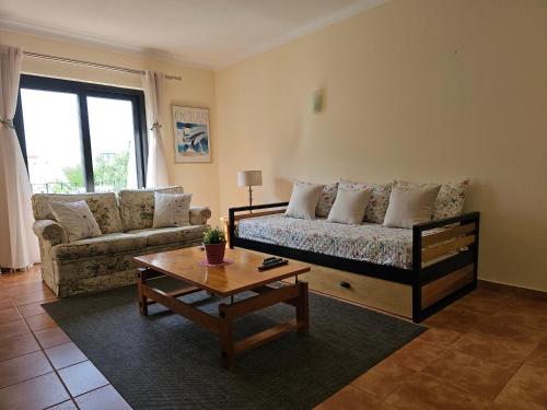 a living room with a couch and a coffee table at T1 Poente da Aldeia 336 Albufeira in Albufeira