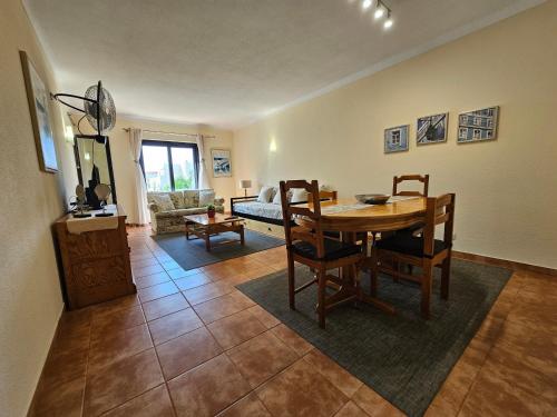- un salon avec une table, des chaises et un canapé dans l'établissement T1 Poente da Aldeia 336 Albufeira, à Albufeira