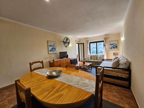 a dining room with a table and a living room at T1 Poente da Aldeia 336 Albufeira in Albufeira