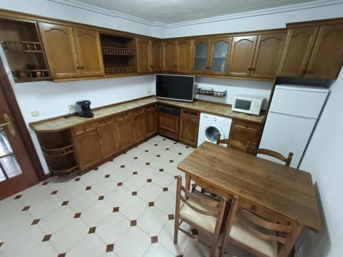 a kitchen with wooden cabinets and a table and a dishwasher at la maison du centre in Irún