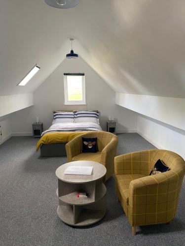 a bedroom with a bed and two chairs at Inkwell in Chippenham