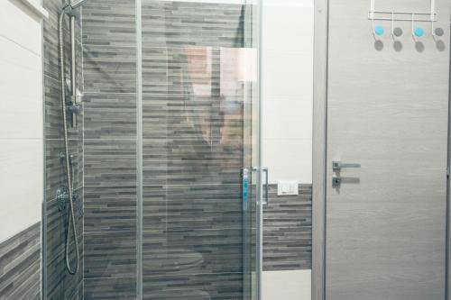 a shower with a glass door in a bathroom at BluMarine Appartaments in Paola