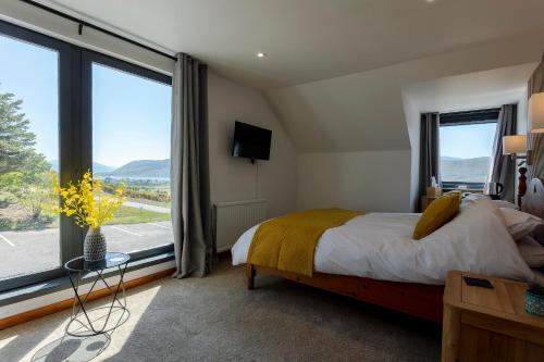 ein Schlafzimmer mit einem Bett und einem großen Fenster in der Unterkunft Lochbroom Lodge in Ullapool