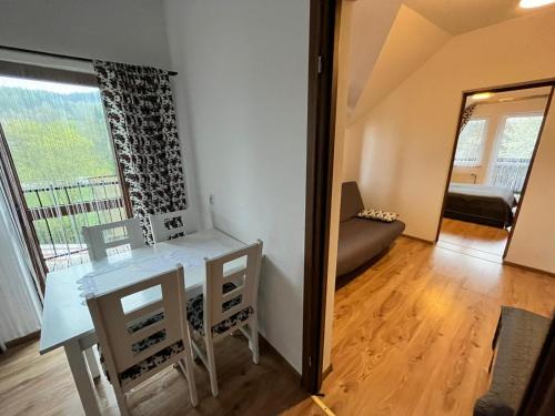 a living room with a table and a couch and a window at "Dom Pod Grzybkiem" in Krościenko