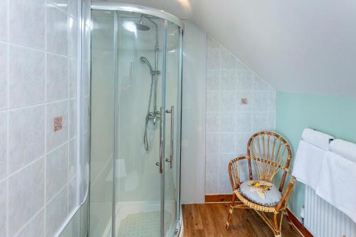 a shower in a bathroom with a chair and a glass shower at Lochbroom Lodge in Ullapool