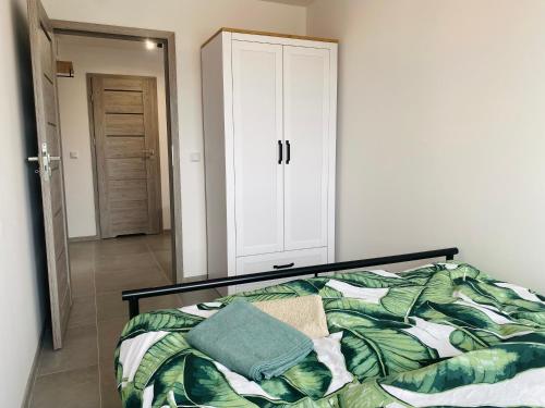 1 dormitorio con 1 cama y armario blanco en Apartament Pocztowa 44, en Świnoujście