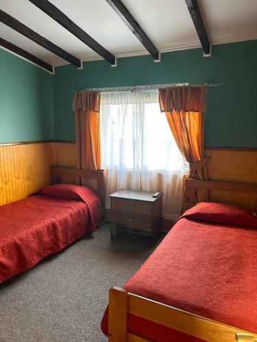 a bedroom with two beds and a window at Hospedaje Polz in Puerto Montt