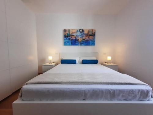 1 dormitorio blanco con 1 cama grande y 2 lámparas en Kennedy Apartments- Porto Cesareo, en Porto Cesareo