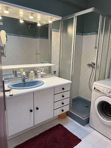 une salle de bain avec un lavabo et une machine à laver dans l'établissement Panorama, à Palavas-les-Flots
