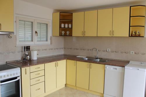 - une cuisine avec des placards jaunes et un évier dans l'établissement Apartman Maslovar, à Kotor