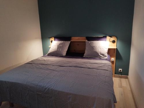1 cama en un dormitorio con una pared verde en Confort sur le port, en Gruissan