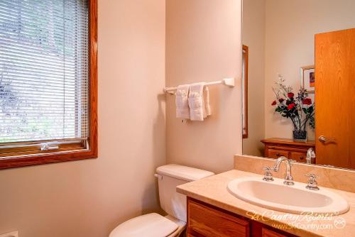a bathroom with a toilet and a sink and a window at Beautiful Mountain Townhome with Private Hot Tub, Steps from Everything Breckenridge! HL305 in Breckenridge