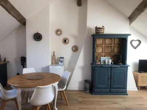 une salle à manger avec une armoire bleue, une table et des chaises dans l'établissement Le Domremy F2 au cœur d'Orléans, à Orléans