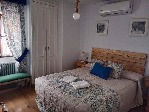 a bedroom with a bed with blue pillows at La Quinteria de Sancho in Argamasilla de Alba