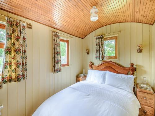 - une chambre avec un lit blanc et un plafond en bois dans l'établissement Mahalia, à Fordham