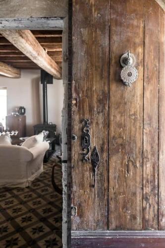 - une porte en bois dans une chambre avec un canapé dans l'établissement Mas Volver Camargue, à Arles