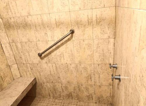 a shower with a stone wall and a bench at terraza y balcón en la zona romantica cerca del mar in Puerto Vallarta