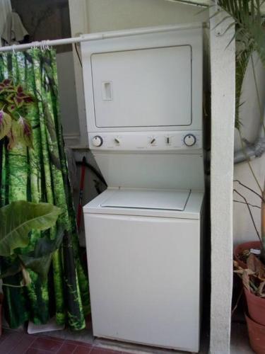 a white refrigerator next to a plant at terraza y balcón en la zona romantica cerca del mar in Puerto Vallarta