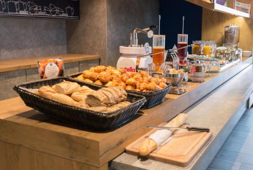 a buffet with bread and pastries on a counter at ibis budget Rennes Rte Lorient in Rennes