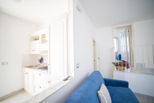 a living room with a blue couch and a window at Dimora Storica La Torre Nel Borgo in Borgagne