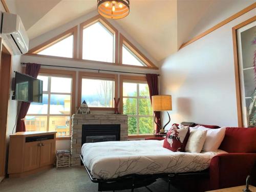 a living room with a bed and a fireplace at Stunning 2BR w Pool, Hot Tub Walk to everything! in Whistler
