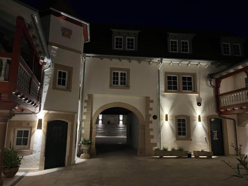 an entrance to a building with an arch at night at Karlbacher Domizil Ferienwohnungen in Großkarlbach
