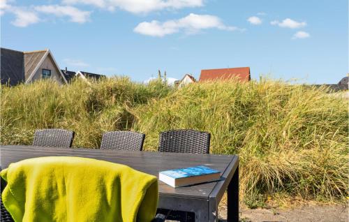 a table with a yellow blanket and a book on it at Beautiful Home In Thyborøn With Sauna in Thyborøn