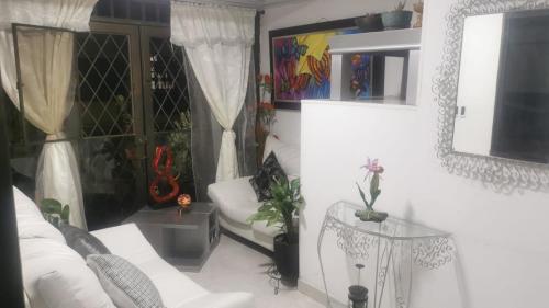 a living room with a white couch and a table at WALOJO¡ Acogedor Apartamento, Excelente ubicación in Neiva